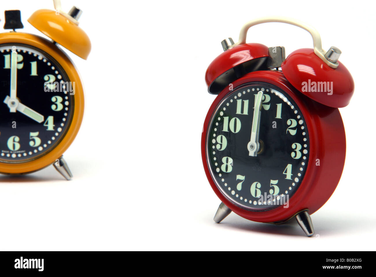 red and orange color alarm clock at twelve oclock isolated on white background Stock Photo Alamy