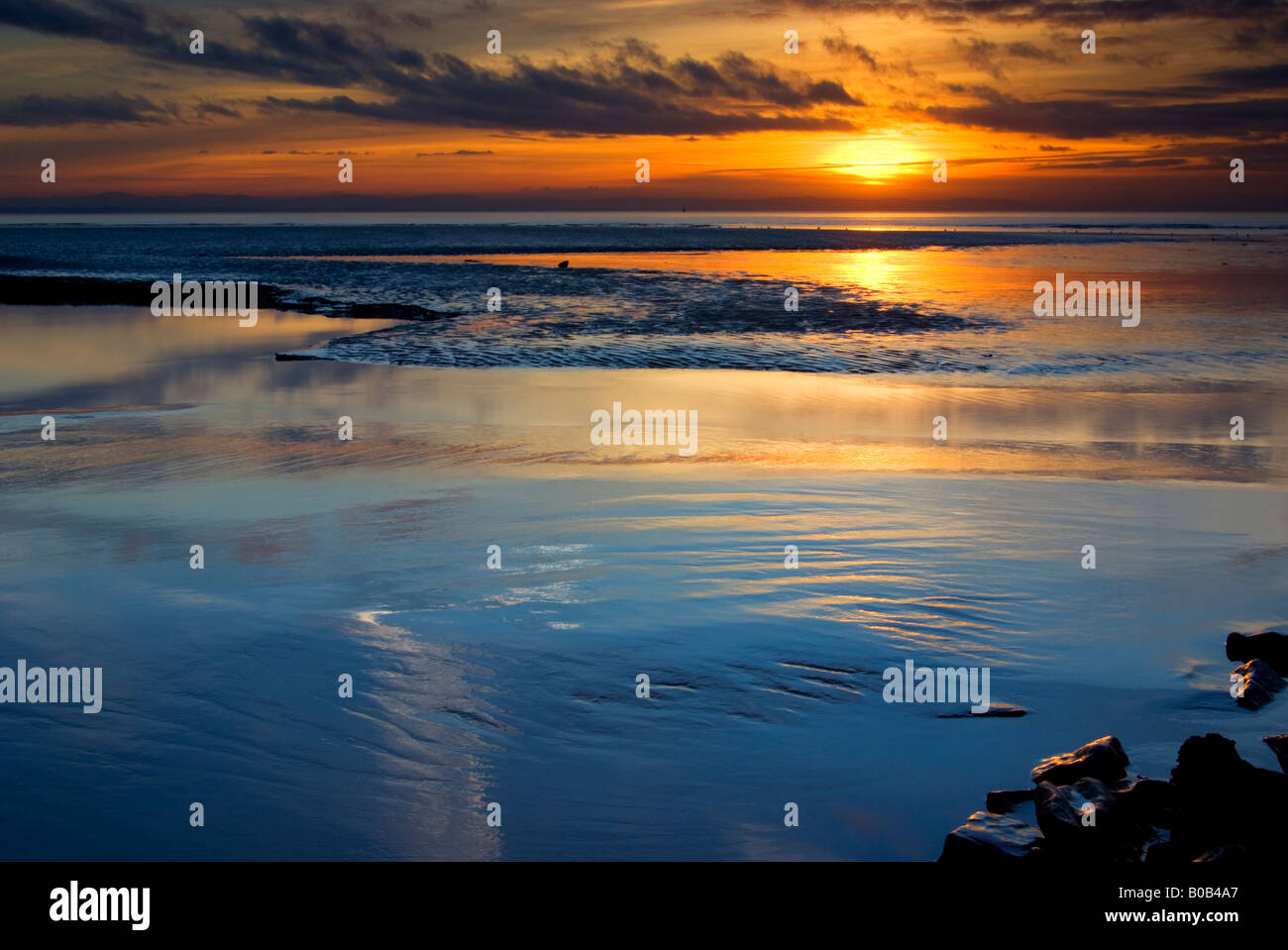 Horizontal Photograph of the Sun setting Over Crosby beach with reflection UK GB EU Europe Stock Photo