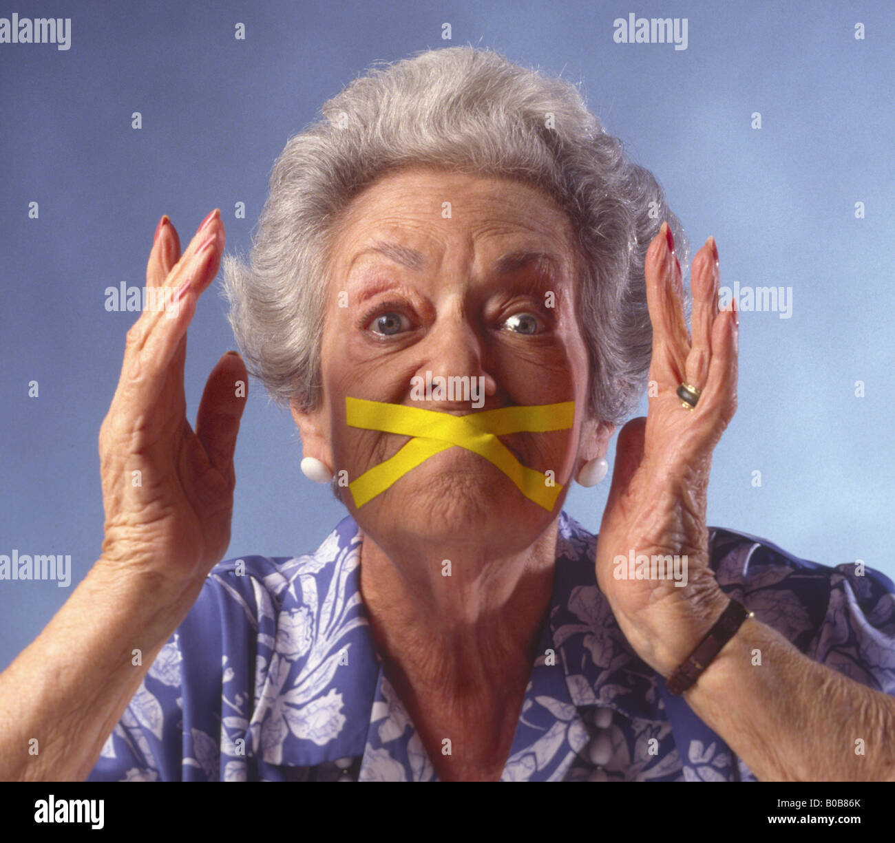 elderly woman with mouth taped shut Stock Photo