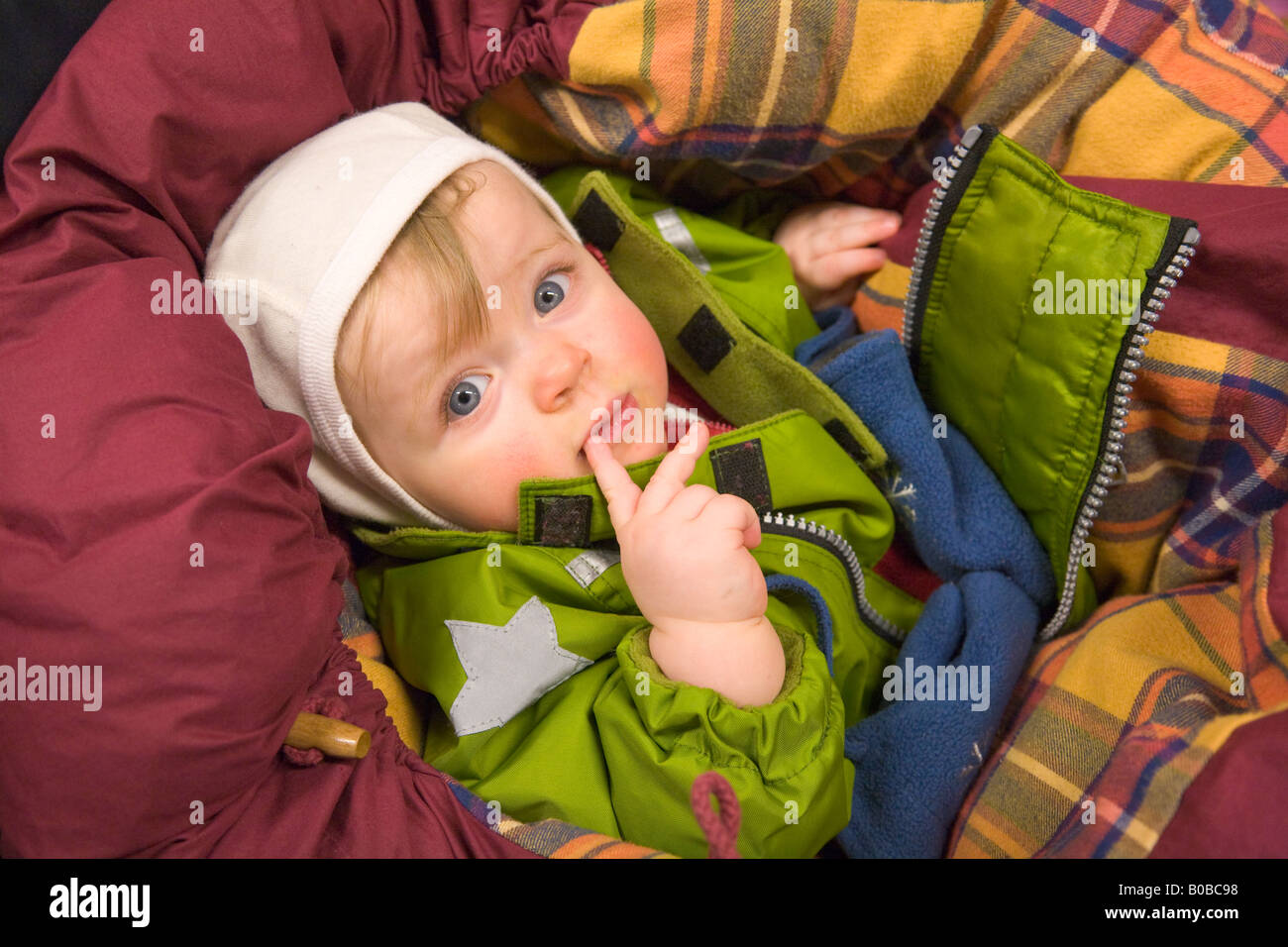 A one year old girl lying in a buggy, well protected against the cold in Kiruna / northern Sweden Stock Photo