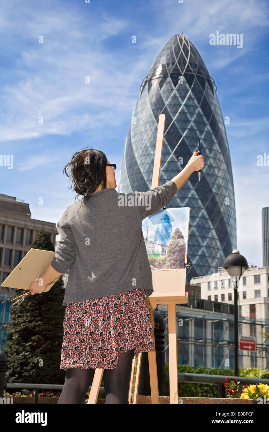 a painter, painting the Gherkin building in London Stock Photo