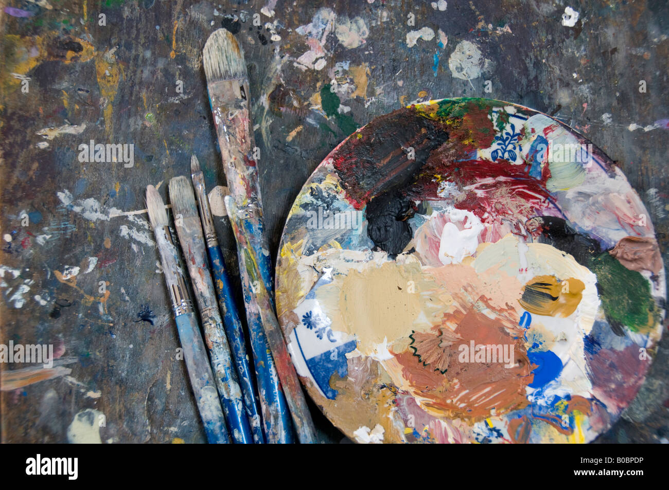 Paint covered pallet and brushes in artists studio Stock Photo - Alamy