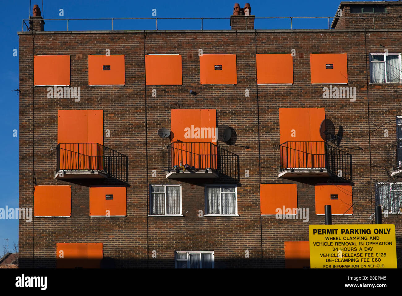 orange boarding encloses empty council flats in Hackney Stock Photo