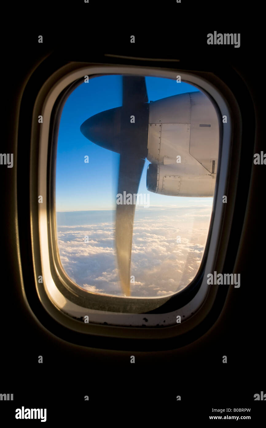 Airplane engine and propeller in flight viewed through the cabin window ...