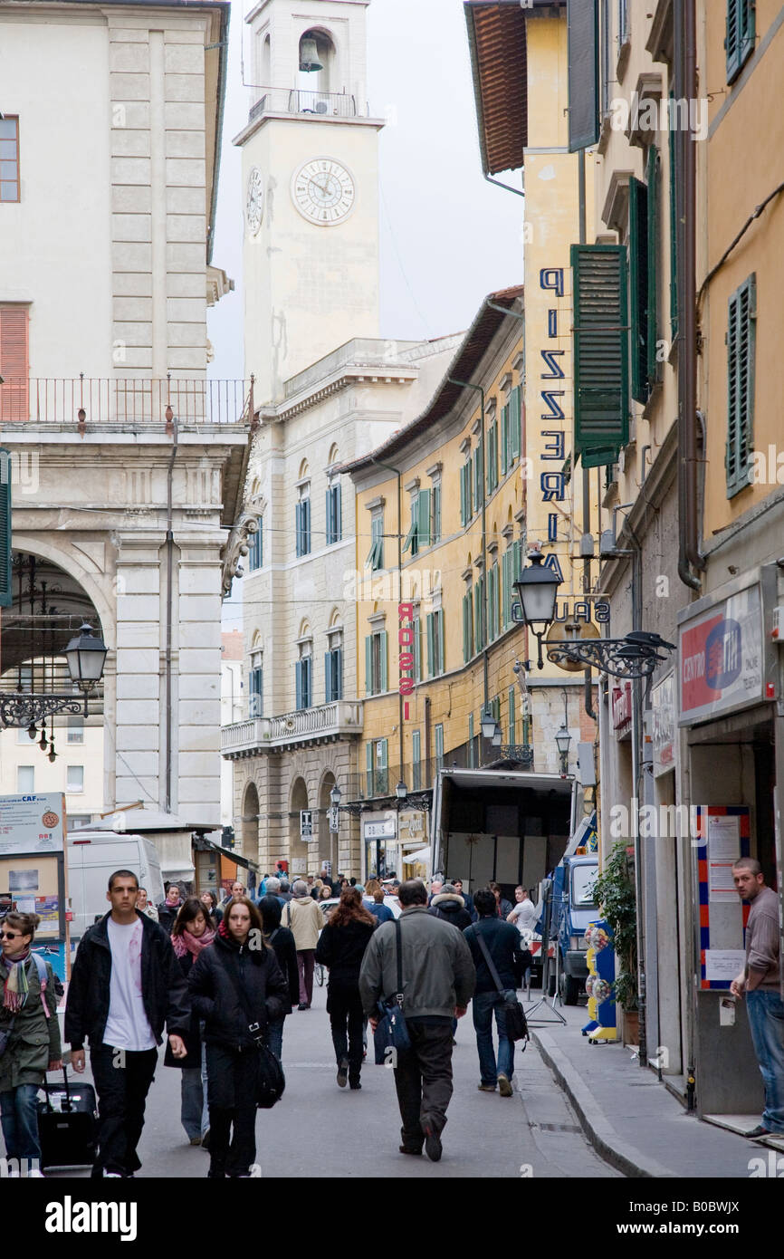 shoppers and shops in the shopping street of Corso Italia Pisa Italy and the tower of Palazzo dell'Orologio Stock Photo