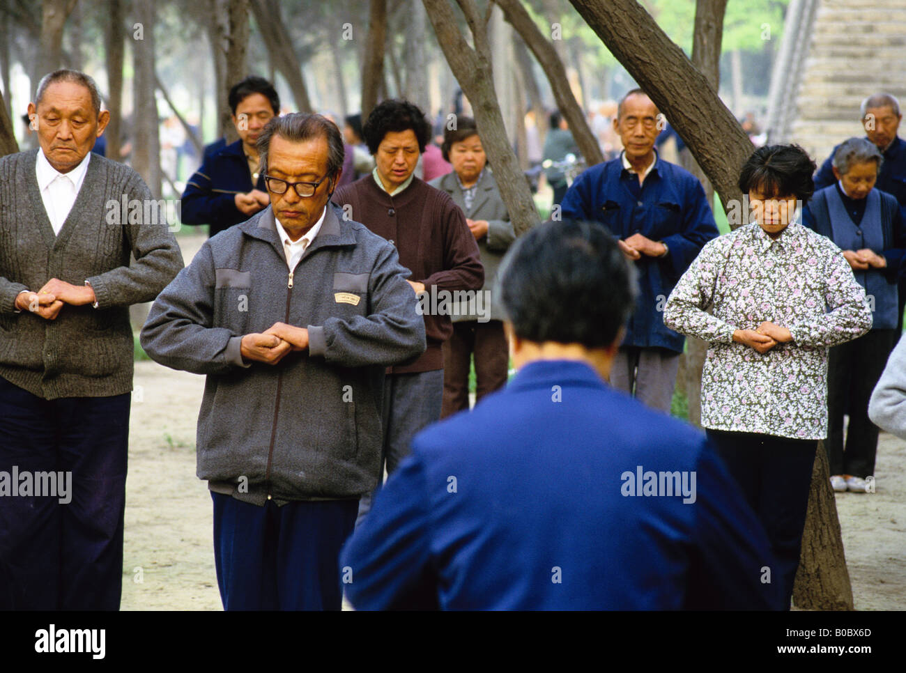 Group practicing qigong in morning in park along old city wall of Xi'an
