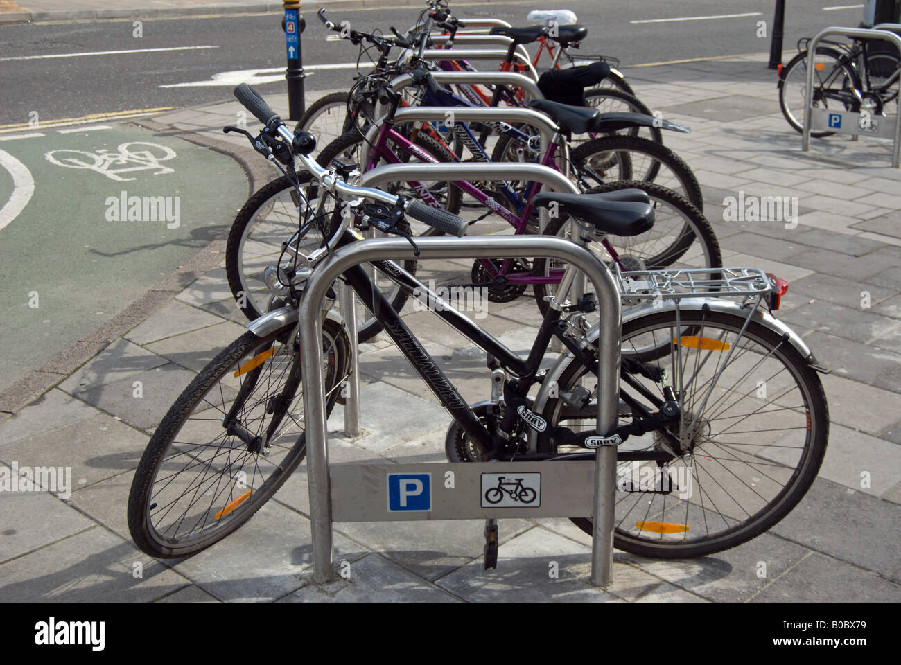 row of parked bicycles, at rack with parking and cycle signs, and ...