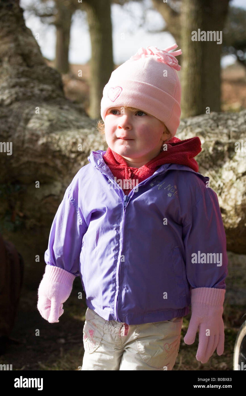 Little girl wrapped up warm to explore the New Forest Hampshire UK Stock Photo