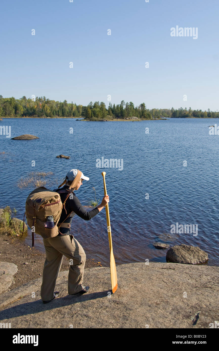 A canoeist carries a pack and a paddle in the Boundary Waters Canoe Area Wilderness in Northern