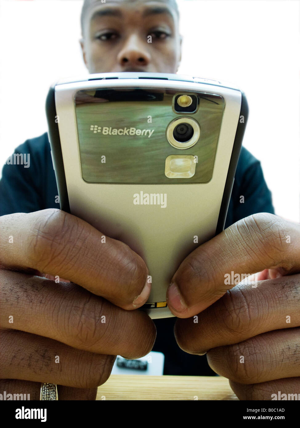 Young black man sending e mail on a Blackberry handheld device Stock Photo