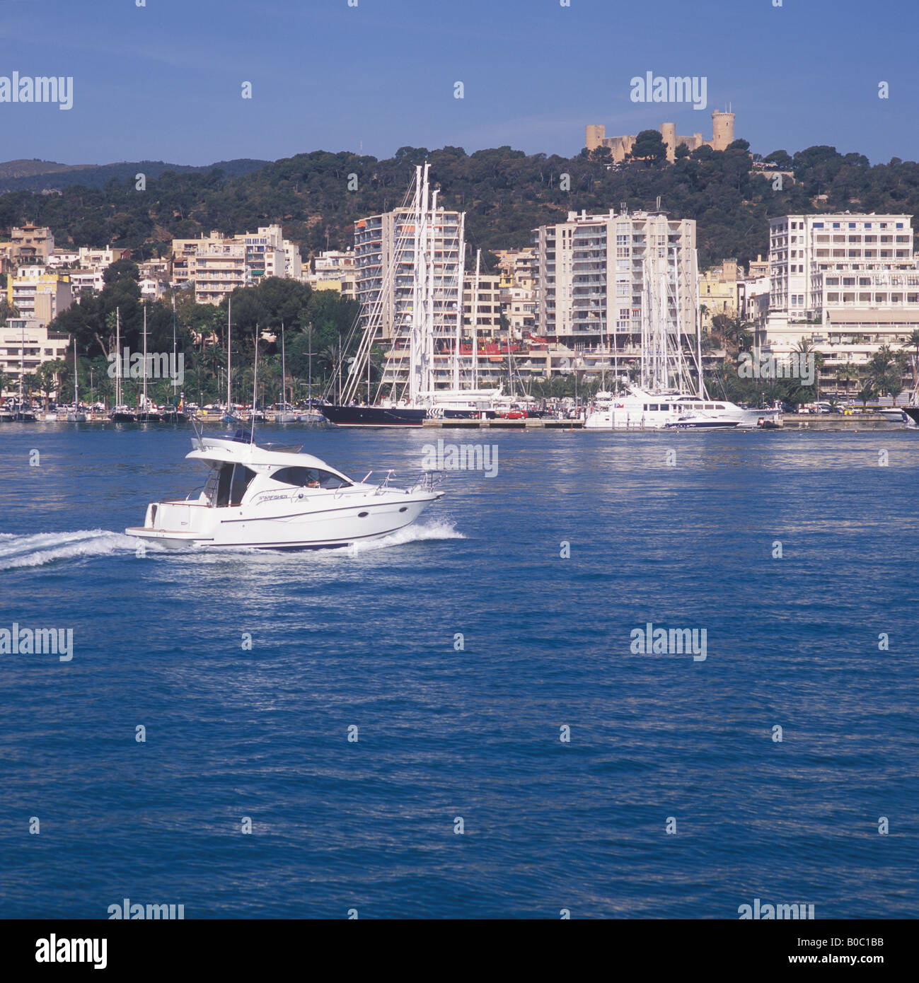Boat Show Bound Starfisher motor launch with Belver Castle and Paseo Maritimo in the background heading for Palma International Stock Photo