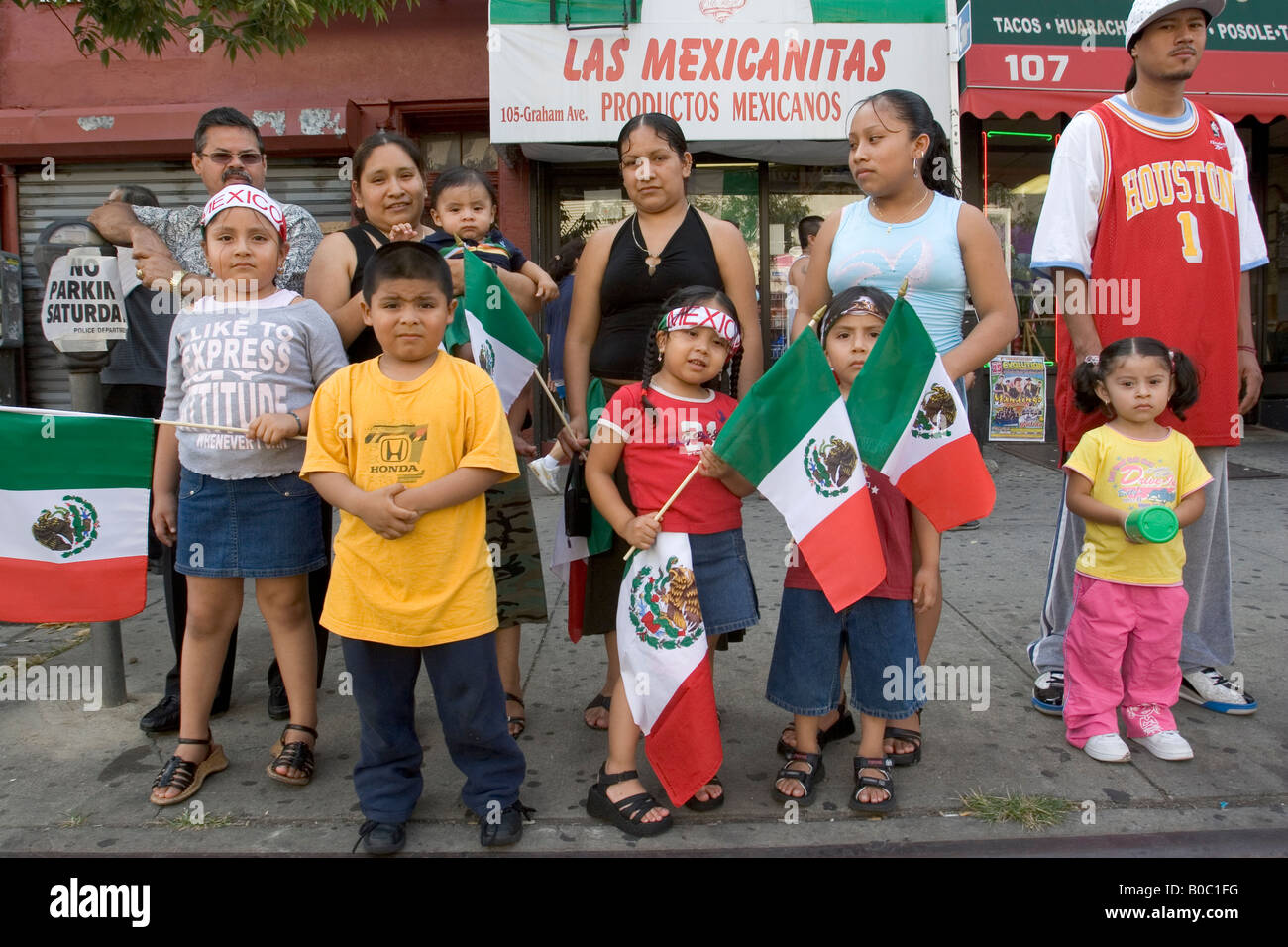 Children and adults display the Mexican flag at a Latinos Unidos parade in Brooklyn New York Stock Photo
