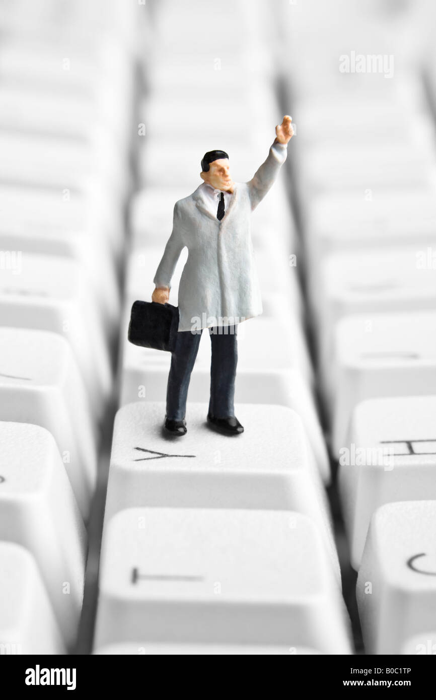 Businessman figurine standing on a computer keyboard Stock Photo