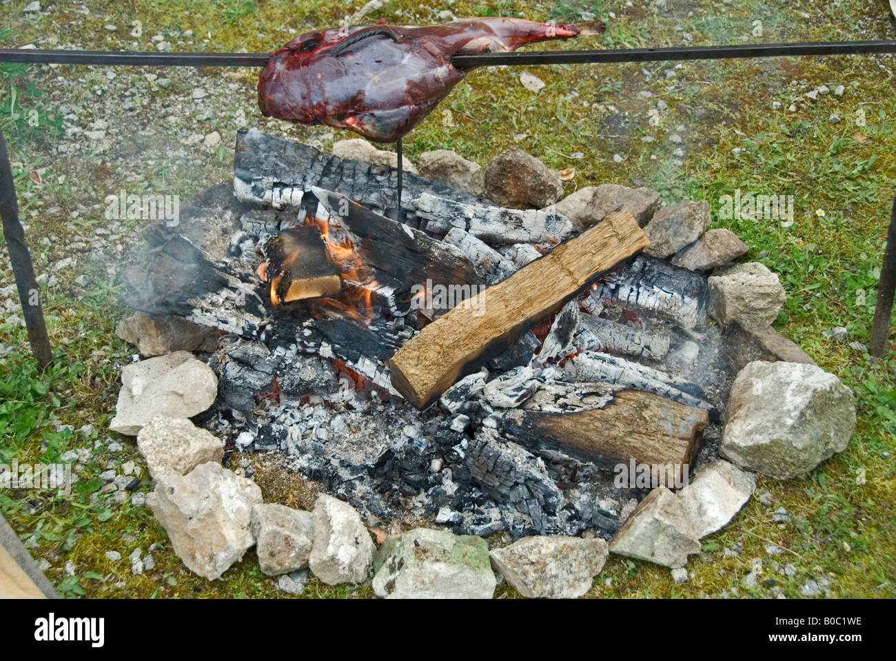 Stock photo of a piece of meat spit roasting over an open fire Stock Photo