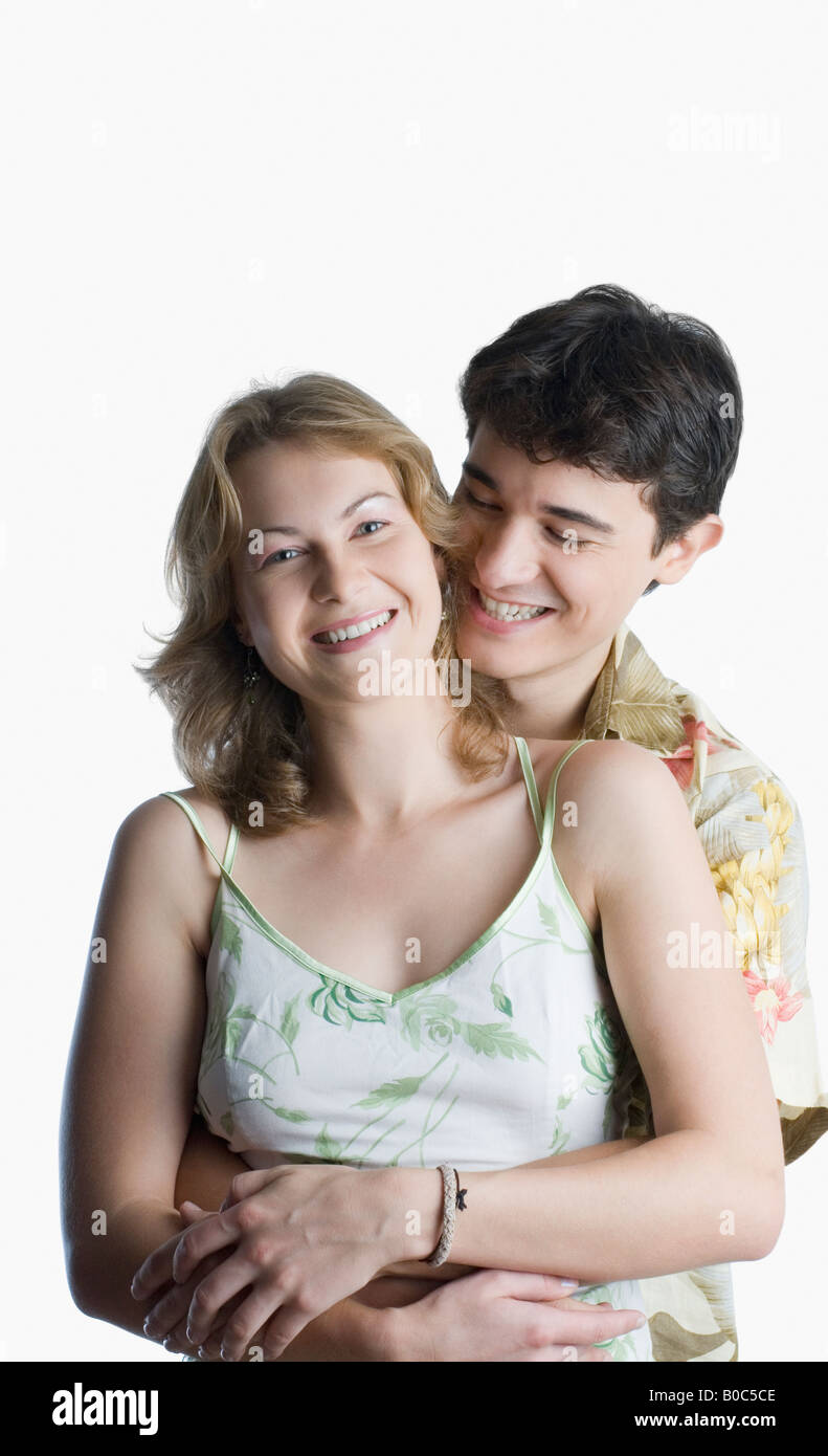 Young man embracing a young woman from behind and smiling Stock Photo ...