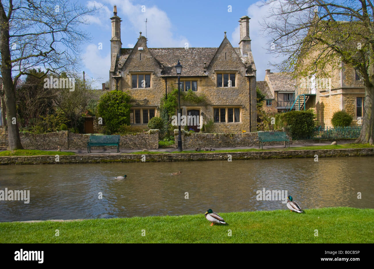 Detached period house on River Windrush in village of Bourton on the Water Cotswolds England UK Stock Photo