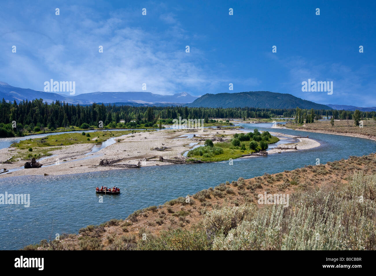 Image of the Snake River curving off into the distance with a raft full of people out for a scenic float trip Stock Photo