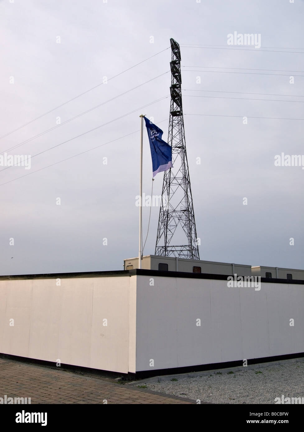 Electricity pylon overshadowing a the site of a new apartment complex Colchester Docks Essex Stock Photo