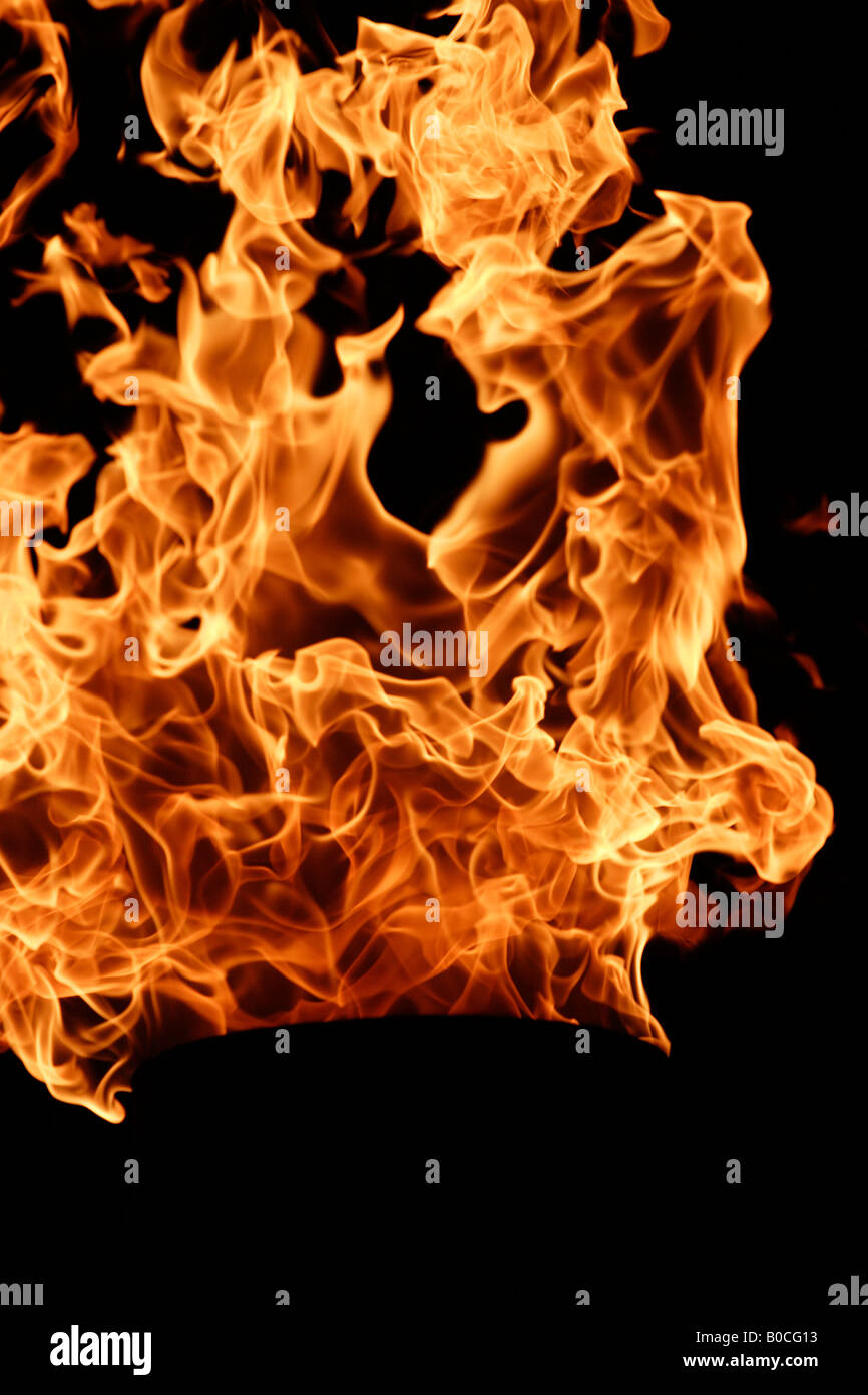 Fire, bright orange flames against [black background], [close up] Stock