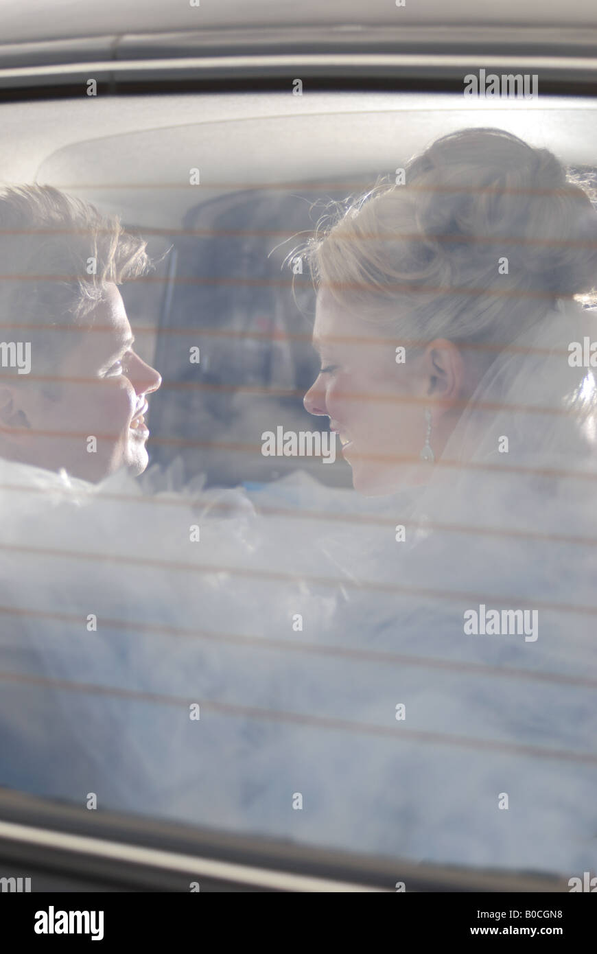 Bride and groom kissing in a wedding car Stock Photo - Alamy