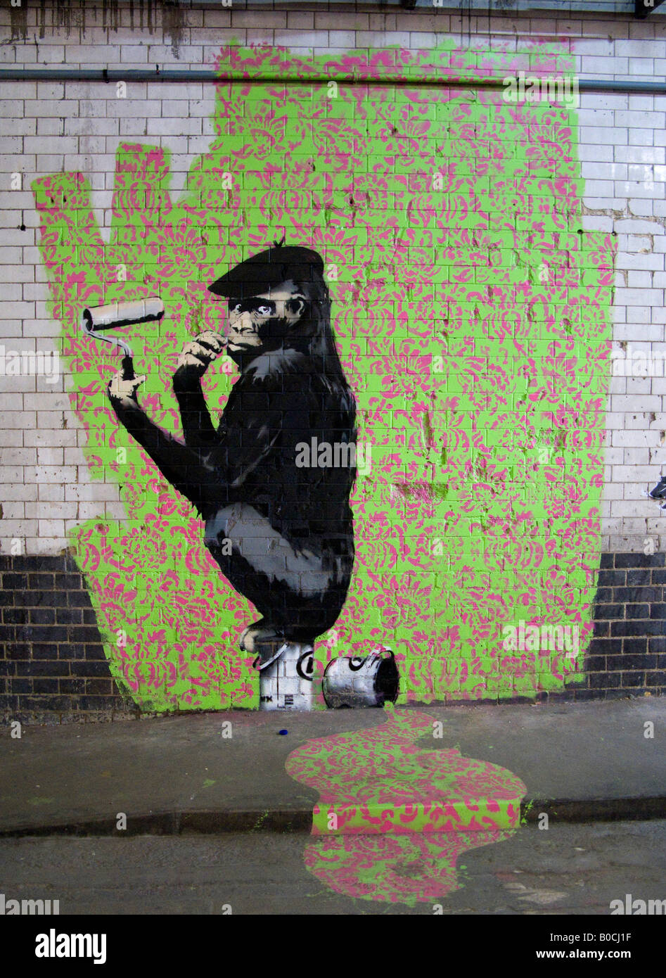 Monkey ape paints wallpaper graffiti with paint roller - image from The  Cans Festival London that artist Banksy helped open Stock Photo - Alamy