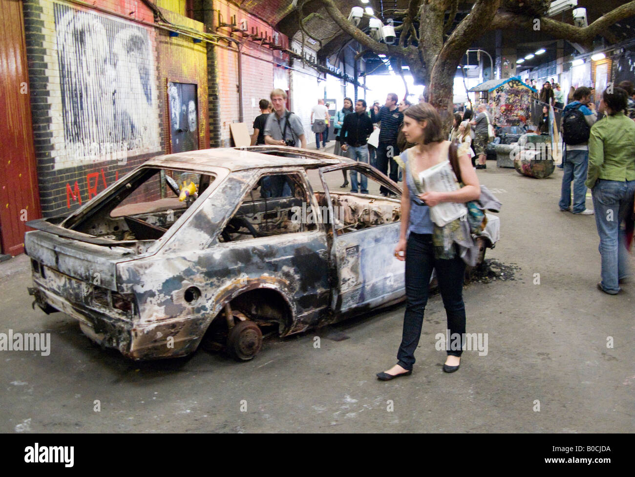 Burnt out stripped car - an image from The Cans Festival, a London street exhibition graffito artist Banksy helped to open Stock Photo