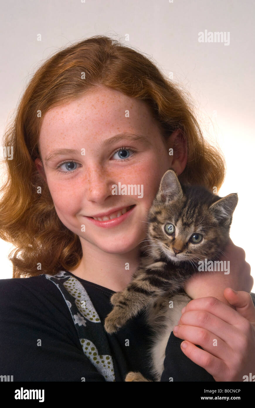 Red Haired Freckle Faced 11 Year Old Girl With Kitten Stock