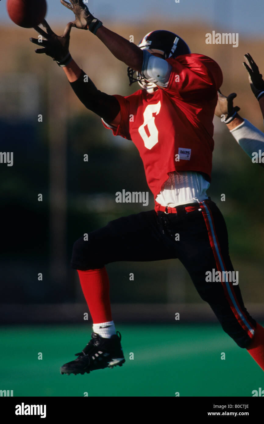 American football player reaching for the ball Stock Photo - Alamy