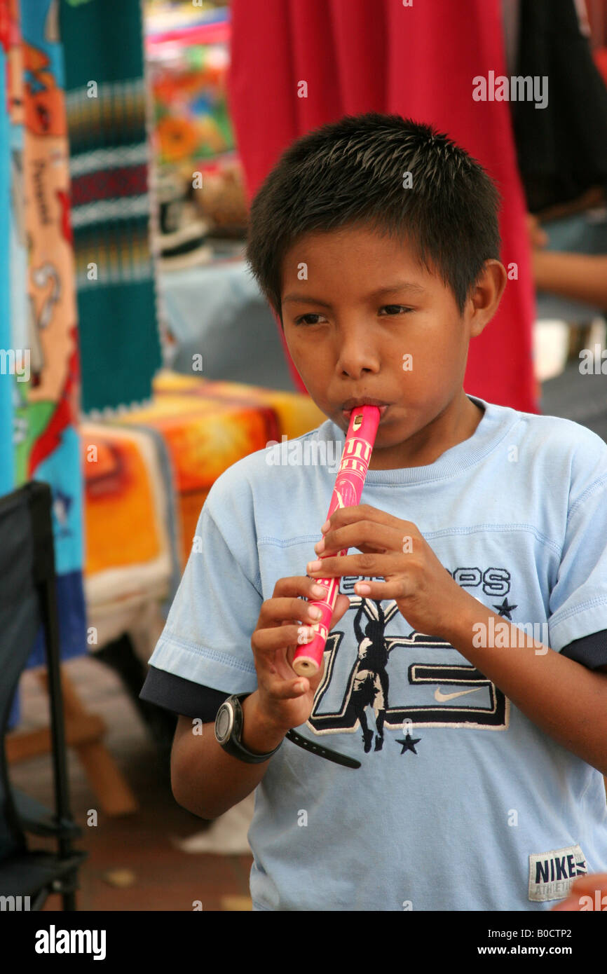 Male indian boy playing a traditional flute in Panama.  For Editorial Use Only. Stock Photo