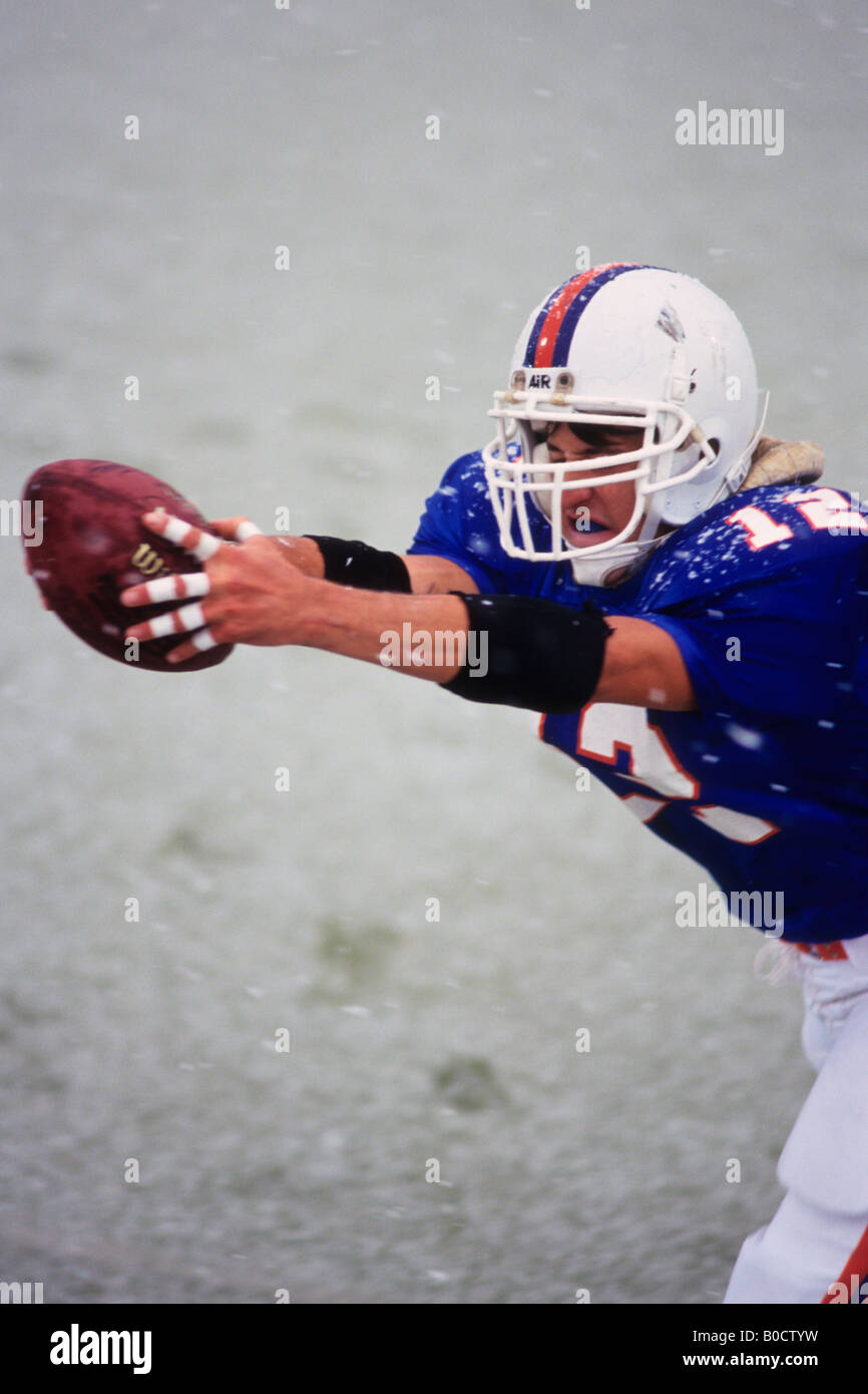 American football player reaching for the ball Stock Photo - Alamy