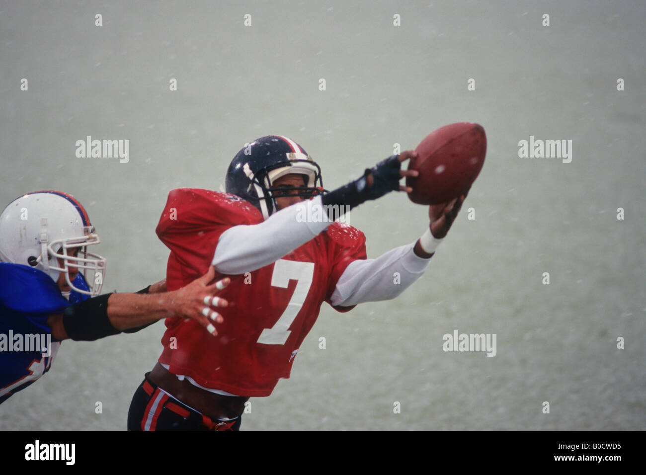 American football player reaching for the ball Stock Photo - Alamy