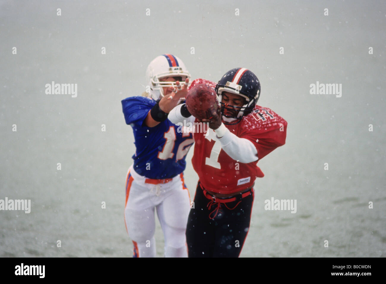 American football player reaching for the ball Stock Photo - Alamy