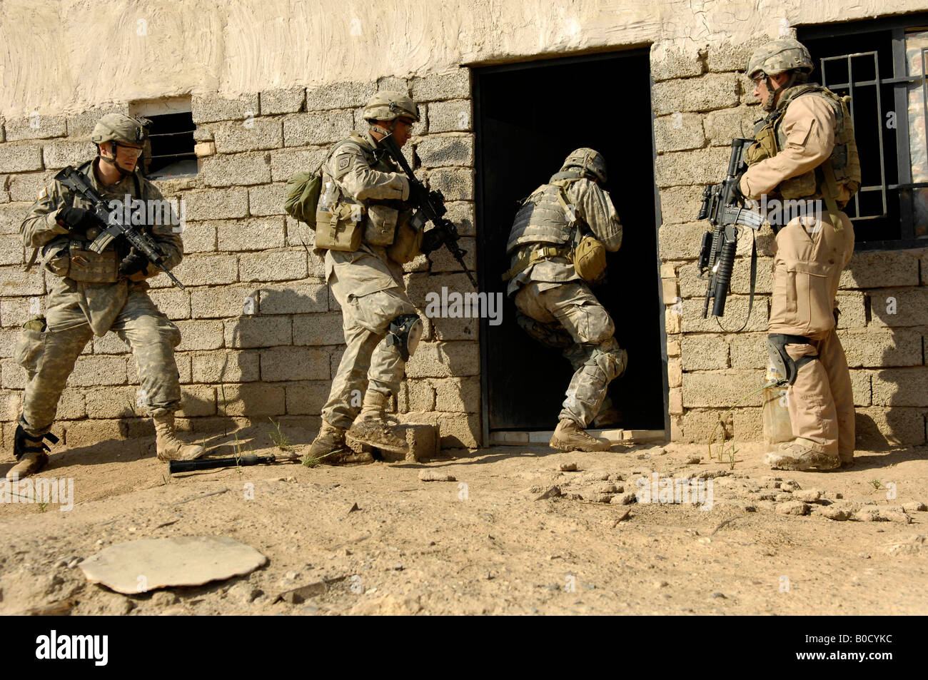 U S Army soldiers breach a house to search for insurgent activities during an operation in Zaghiniyat Iraq on March 29 2007 Stock Photo