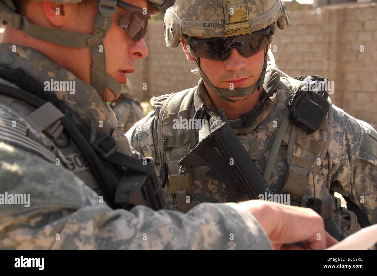 U S Army Staff Sgt Terry Goble left briefs Sgt Robert Klotz prior to a joint patrol through a neighborhood in Shulla Iraq Stock Photo
