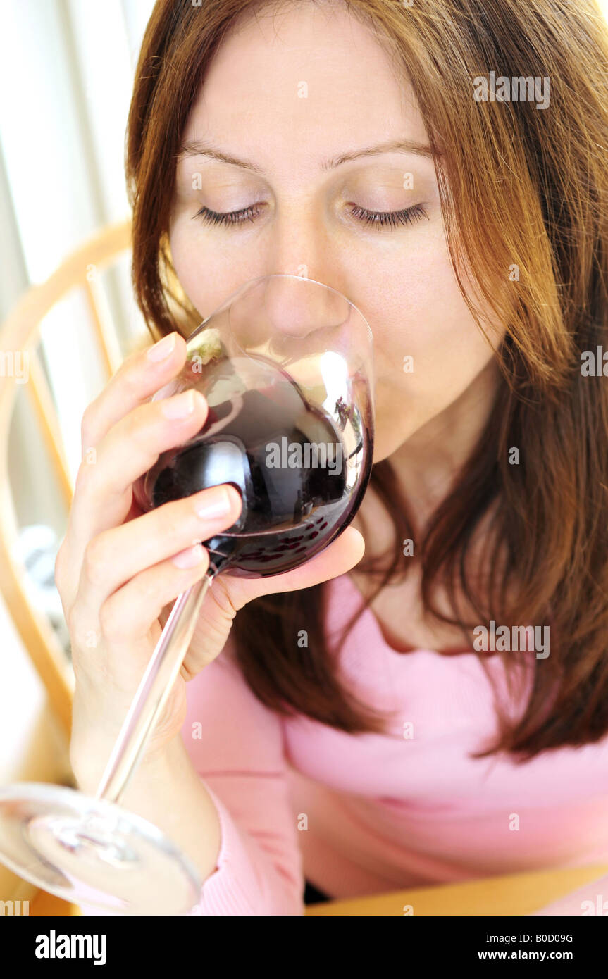 Mature woman holding a glass of red wine Stock Photo - Alamy