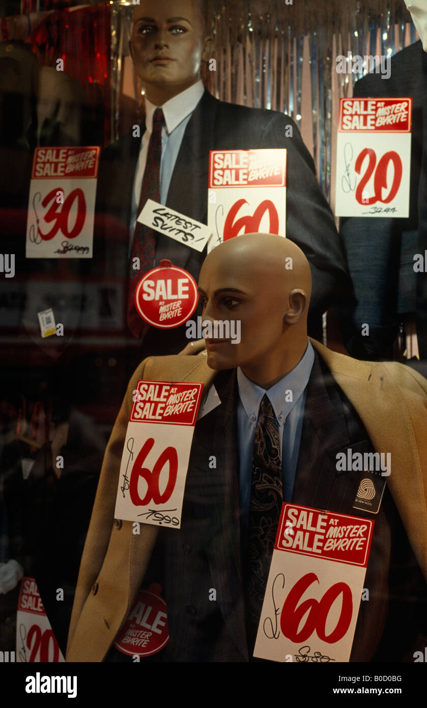 Mannequins wearing bargain office suits and coats fill a Mr Byrite mens' cheap clothes shop window during a sale in London Stock Photo