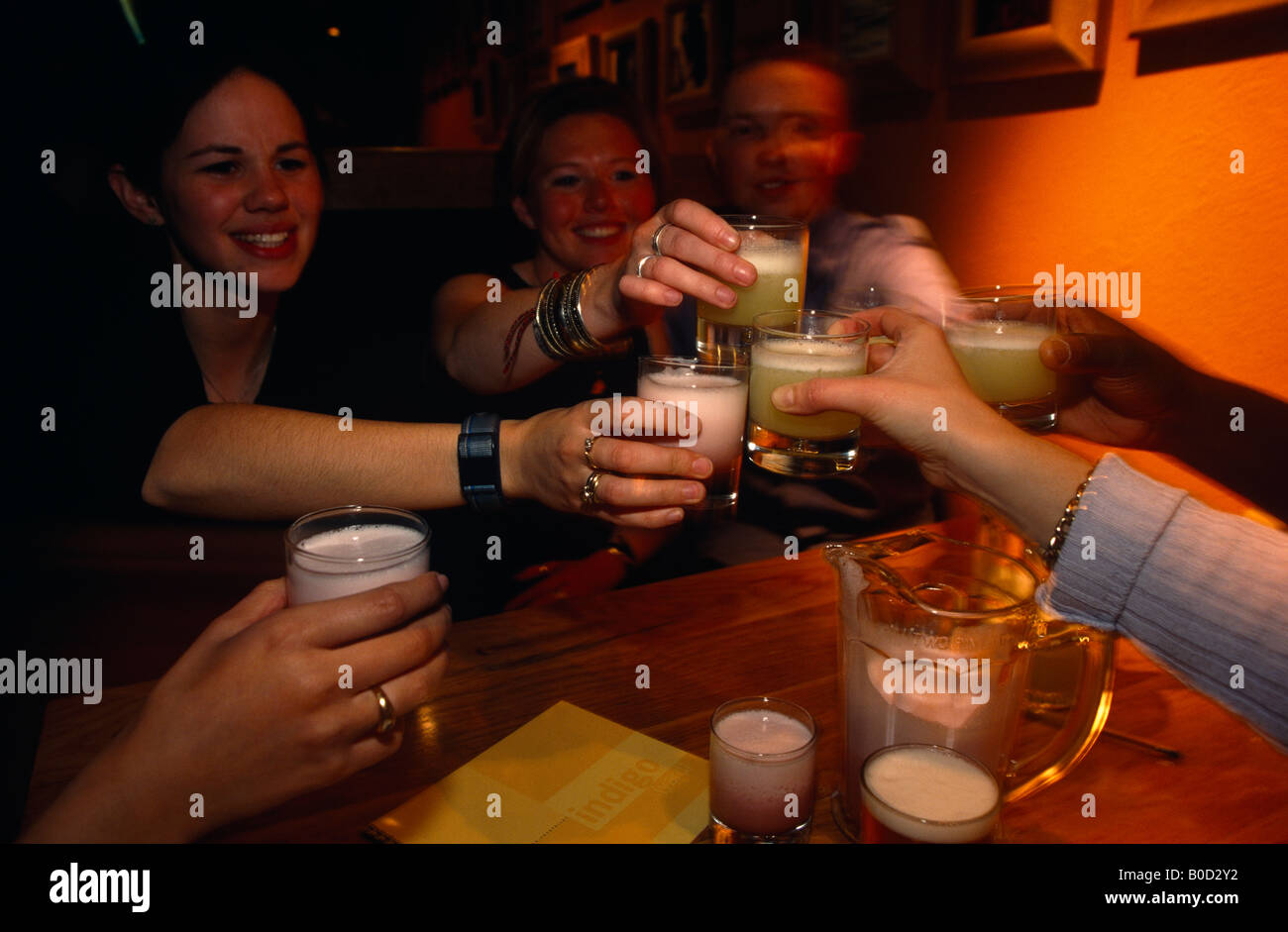 Old university friends share a toast of Margarita cocktails in an