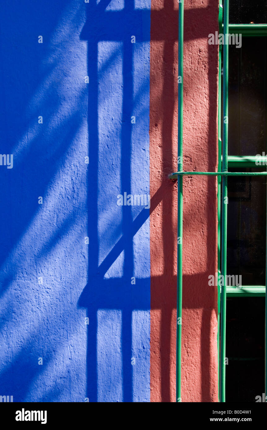 Dappled shadows on a window at Frida Kahlo's house known as the Blue House. Bright blue with contrasting green colour Stock Photo