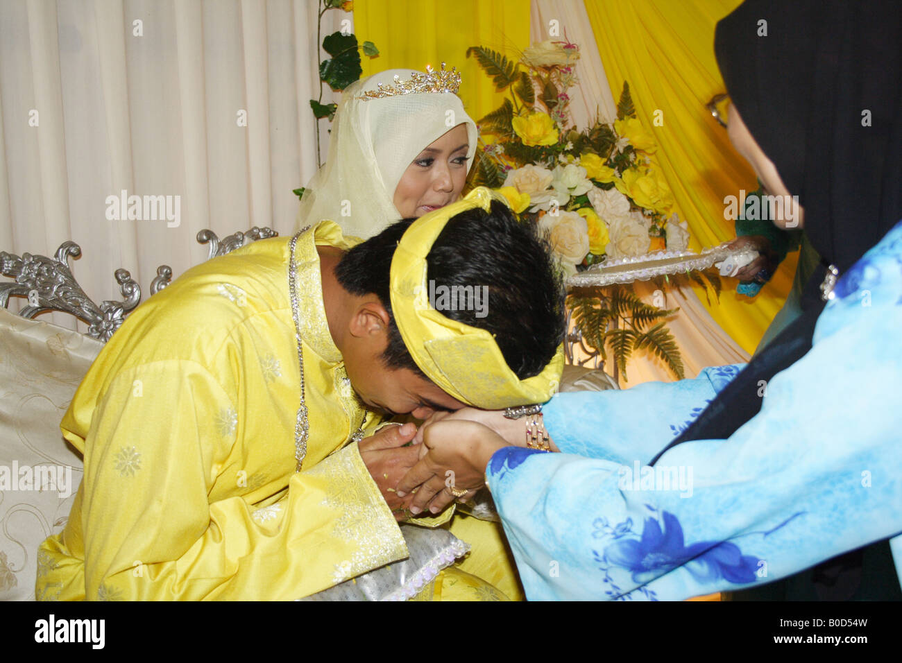 Malay bridegroom kissing hands of well wisher Stock Photo