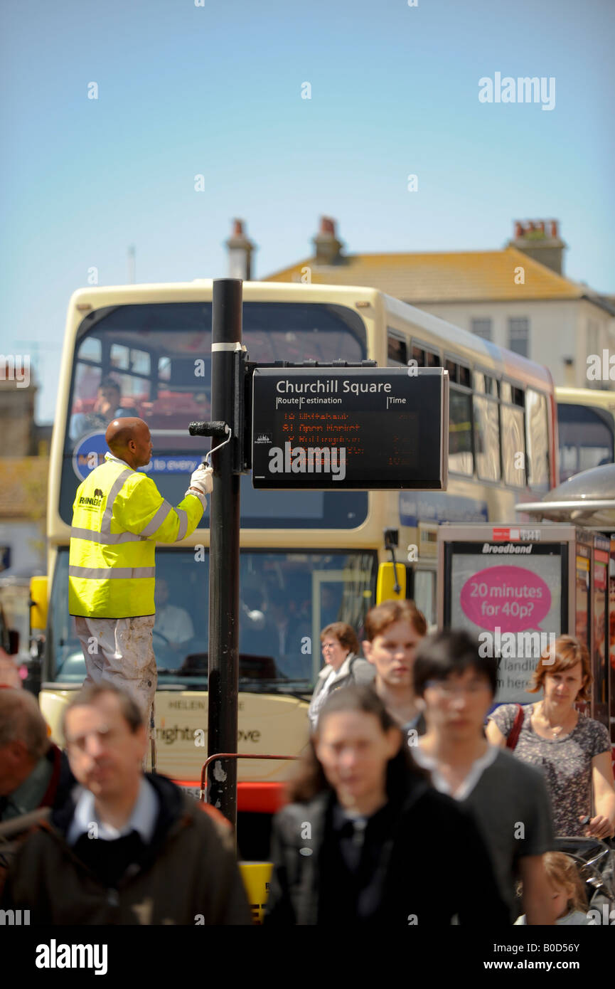 A workman painting a bus stop in Churchill Square, Brighton. Picture by Jim Holden. Stock Photo