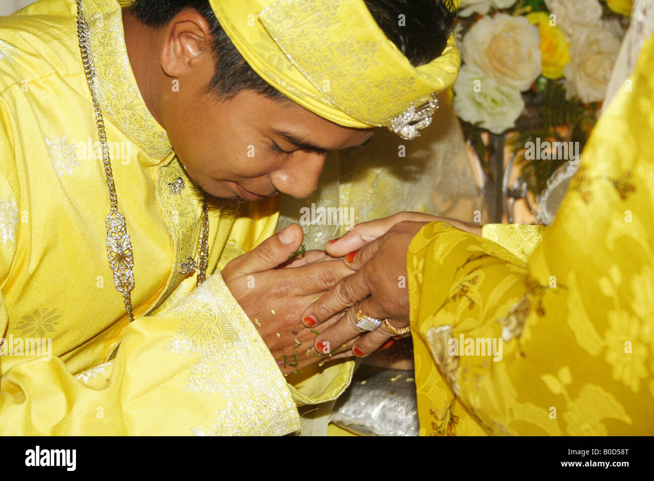 Malay bridegroom kissing hands of well wisher Stock Photo