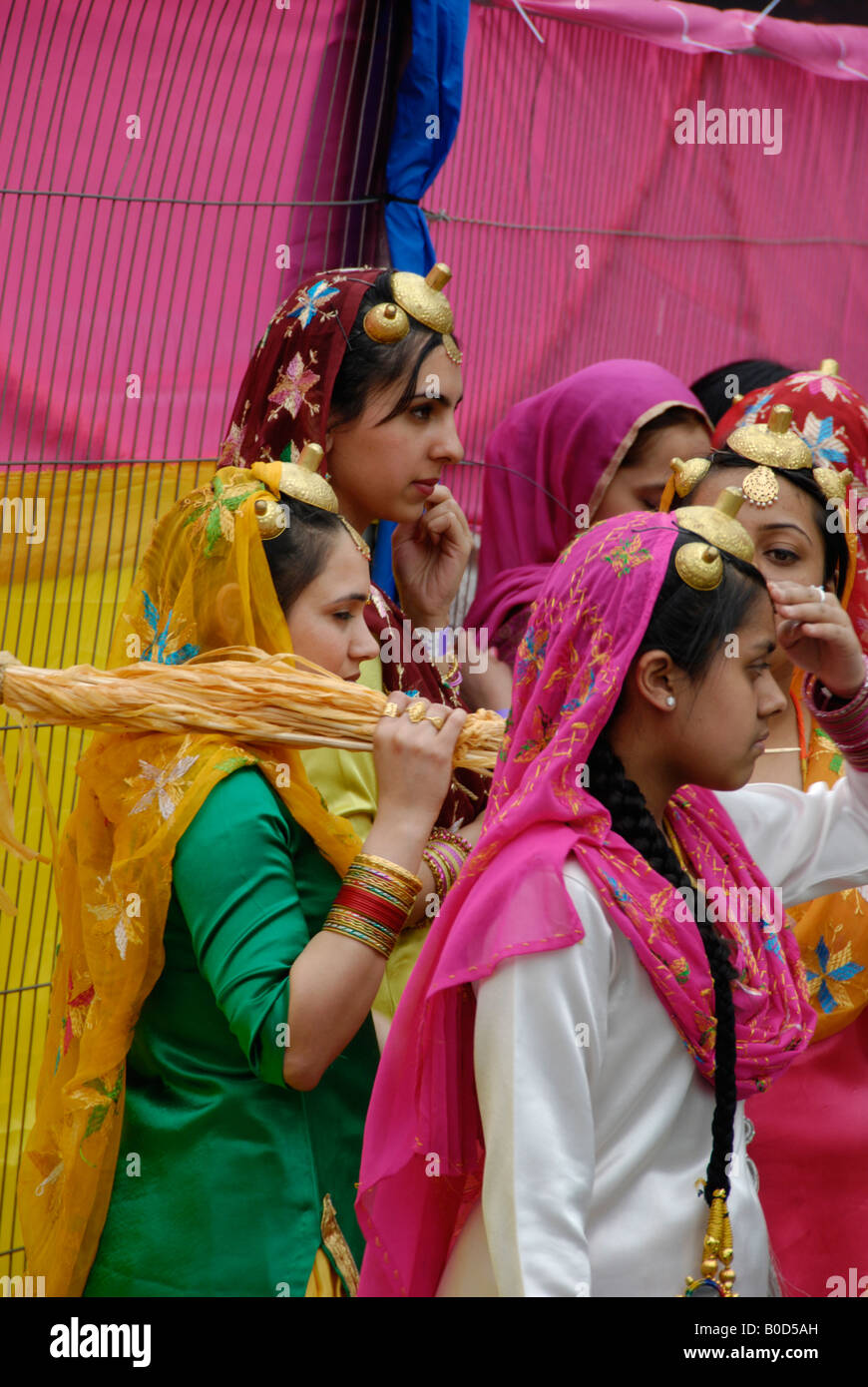 Sikh female dancers in colourful traditional costumes preparing to go onstage at the Vaisakhi Sikh New Year Festival in London Stock Photo