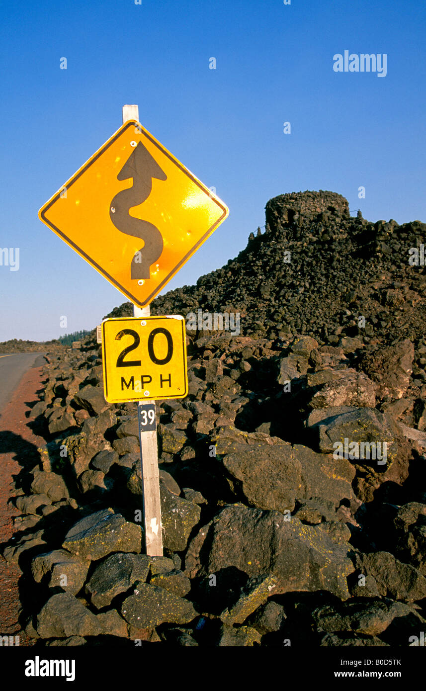 A road sign warns drivers of a curvy road through an alpine lava flow on the McKenzie Pass Scenic Byway Stock Photo
