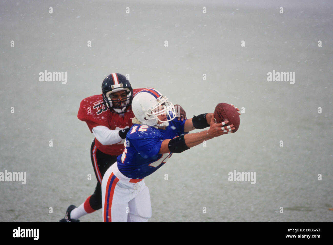 American football player reaching for the ball Stock Photo - Alamy