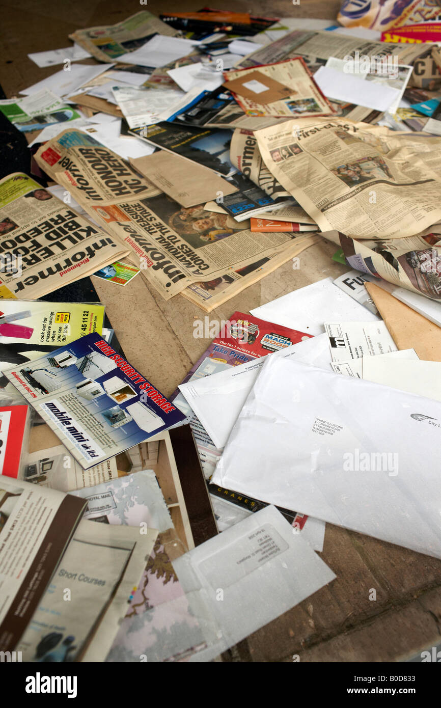 Unwanted mail piling up behind the front door of a shop that has closed down Stock Photo
