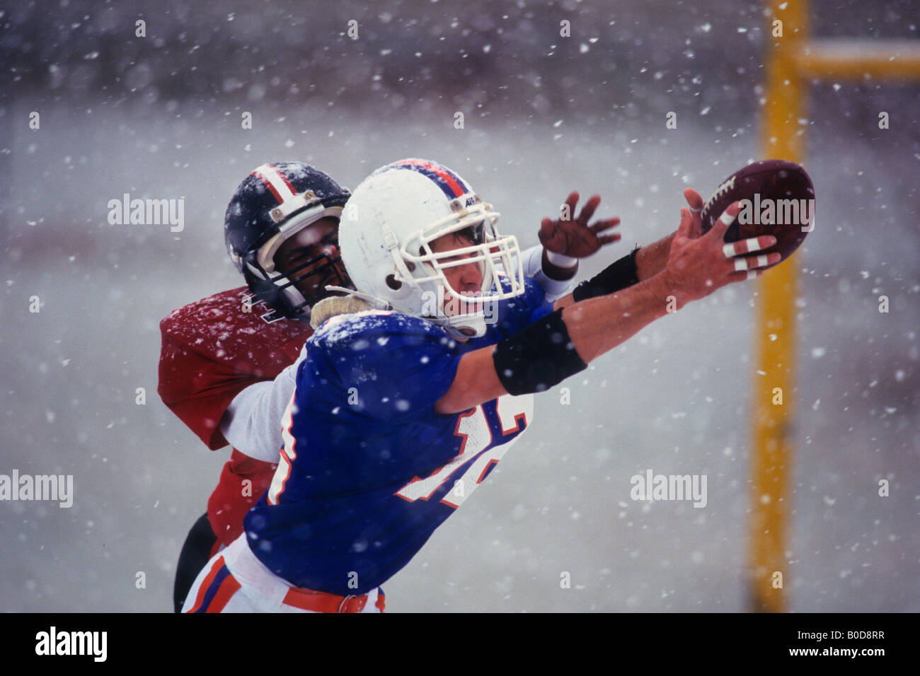 American football player reaching for the ball Stock Photo - Alamy