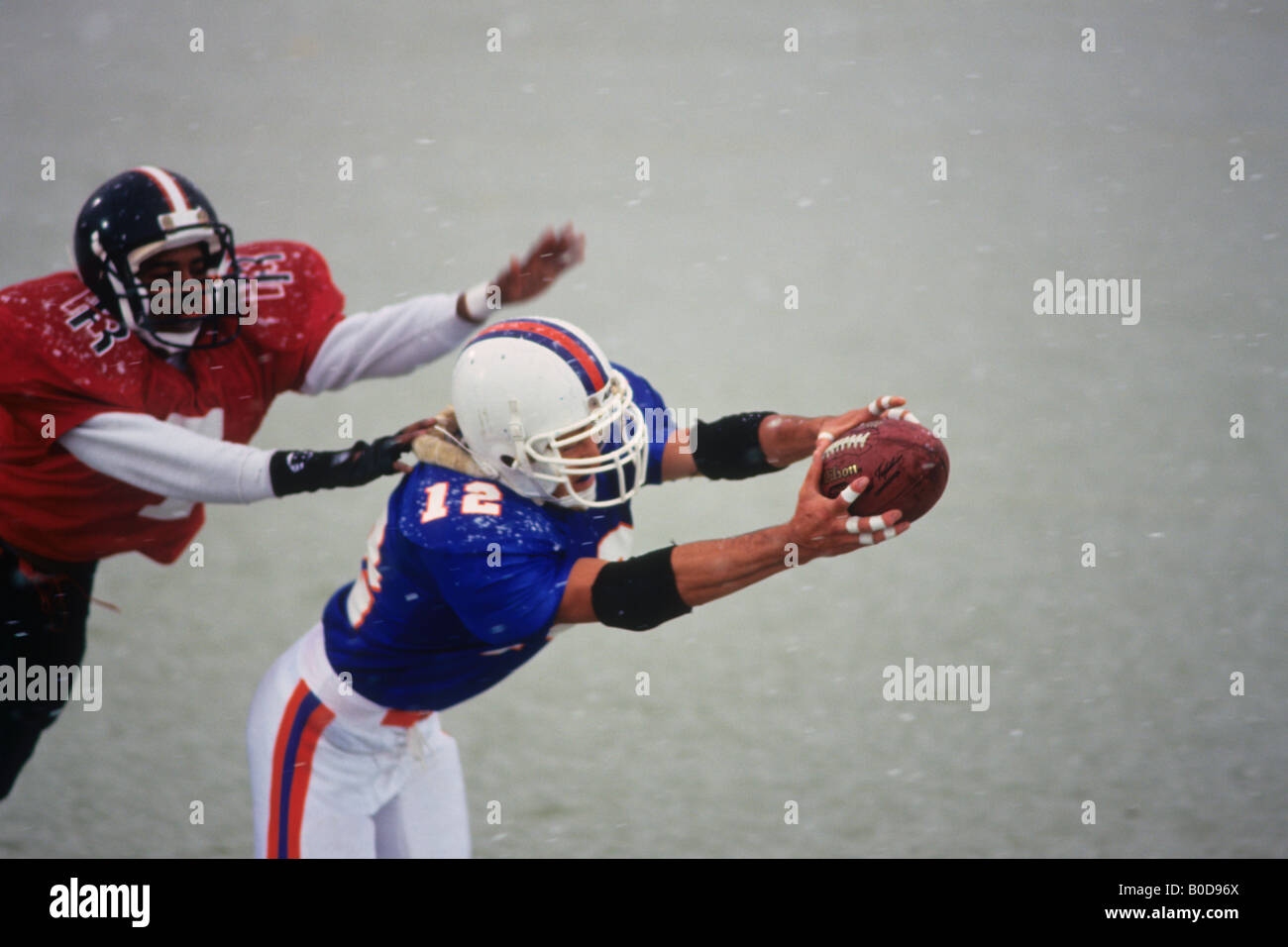 American football player reaching for the ball Stock Photo - Alamy