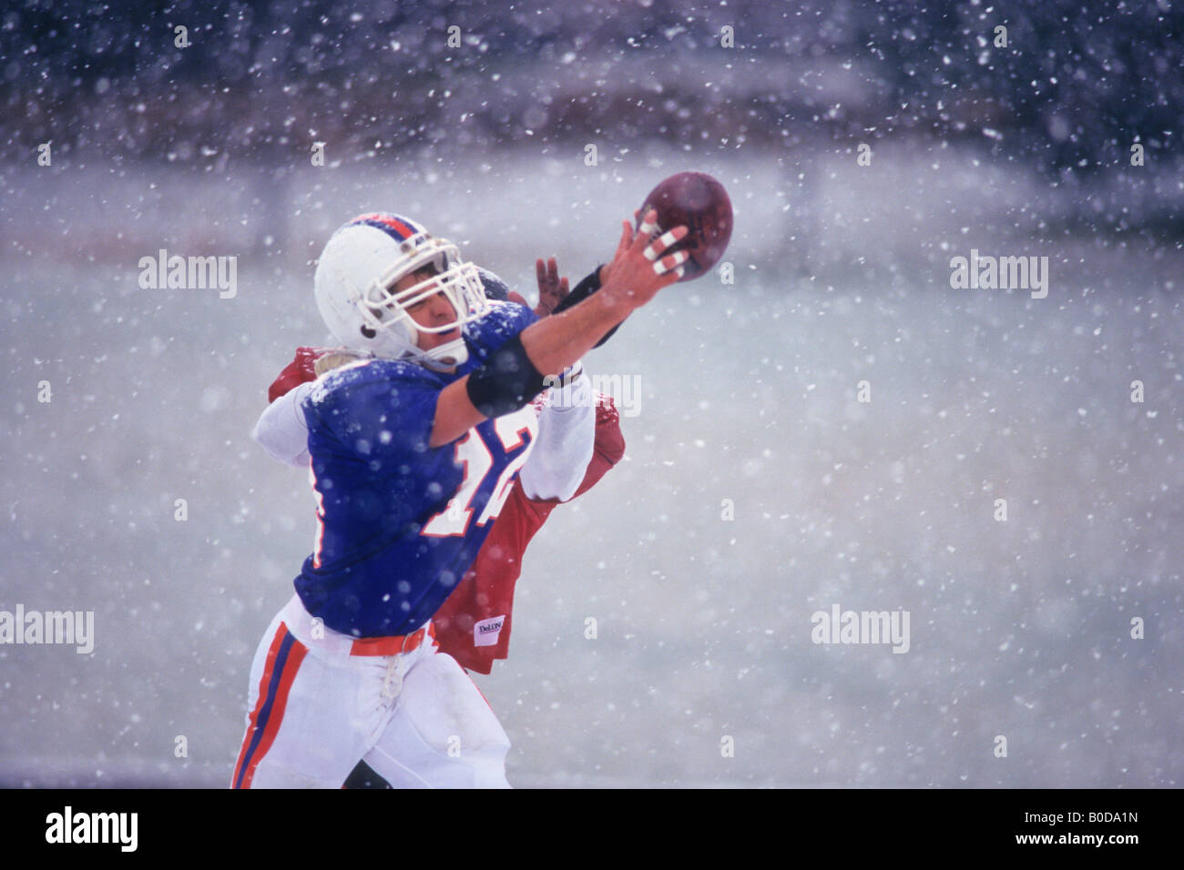 American football player reaching for the ball Stock Photo - Alamy