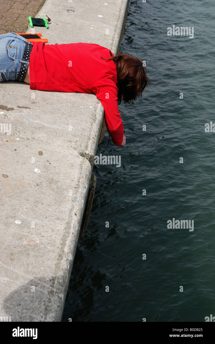 Girl fishing for crabs in Dartmouth, UK Stock Photo