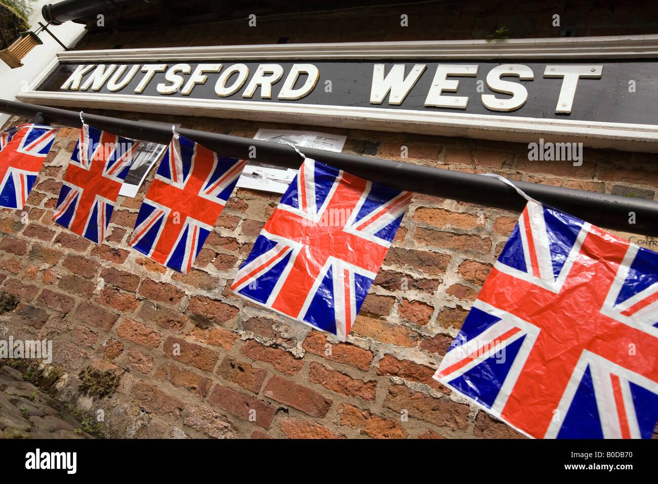 UK Cheshire Knutsford Heritage Centre Union jack flag bunting hanging below old railway station sign Stock Photo